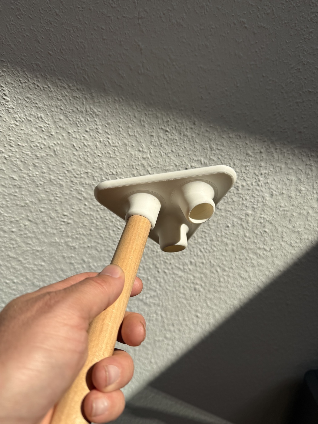 Michael Damböck hält den deltapod Verbinder in der Hand – Einblick in die Fertigung in Stuttgart